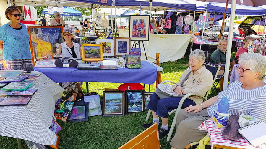 Happy artists sitting in a stall at the Beaudesert Markets
